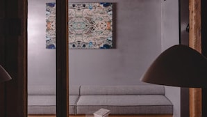 A room with a grey sofa, a wooden ceiling, and a wall-mounted abstract painting. - MU HEN KO Tokyo (Tokyo)