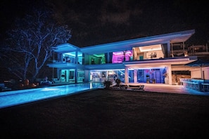 A modern multi-story house with a swimming pool, outdoor seating, and a well-lit exterior. - Villa Enjoy - Modern Luxury  in Patong (Tambon Patong)