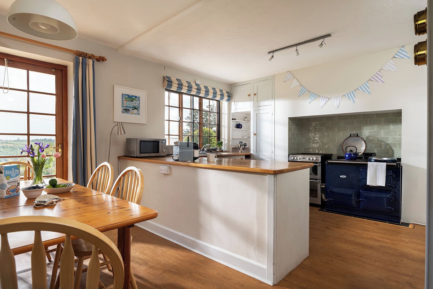Une cuisine avec un îlot central en bois, une cuisinière et un four à micro-ondes.