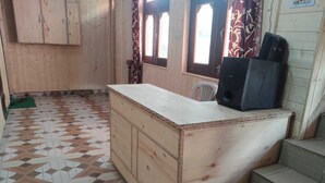 A kitchen with a wooden counter, a speaker, and patterned floor tiles. - Kaas Home Stay (Chitkul)