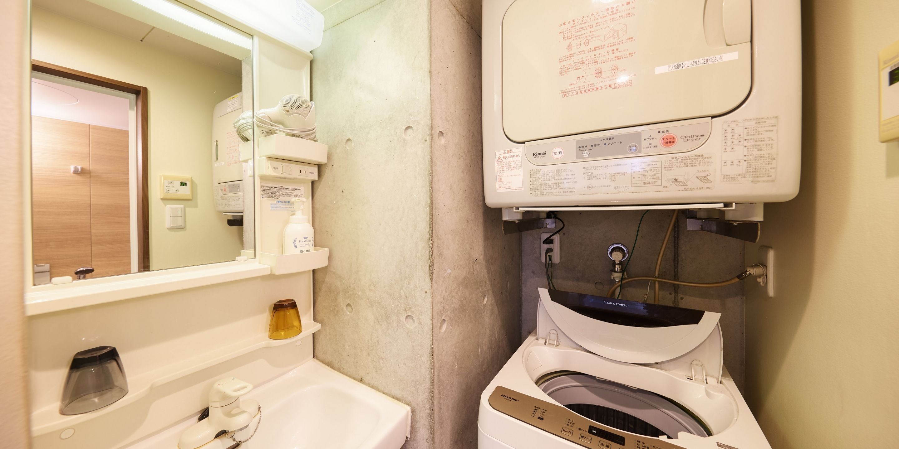 Een kleine badkamer met een wastafel, spiegel en een wandgedroogde kast.