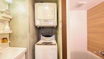 A compact bathroom with a toilet, a small sink, and a mirror.