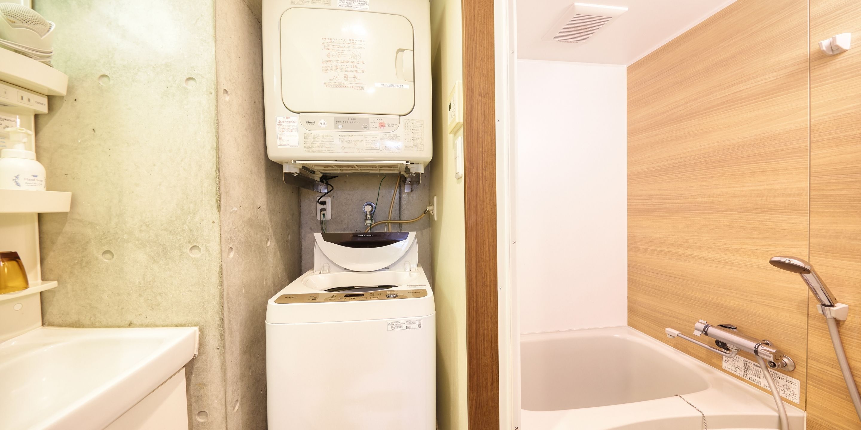 A bathroom with a white sink, a built-in heater, and a bathtub with a showerhead.