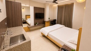 A modern hotel room with a bed, desk, and built-in TV. - Studio 24 (Jaipur)