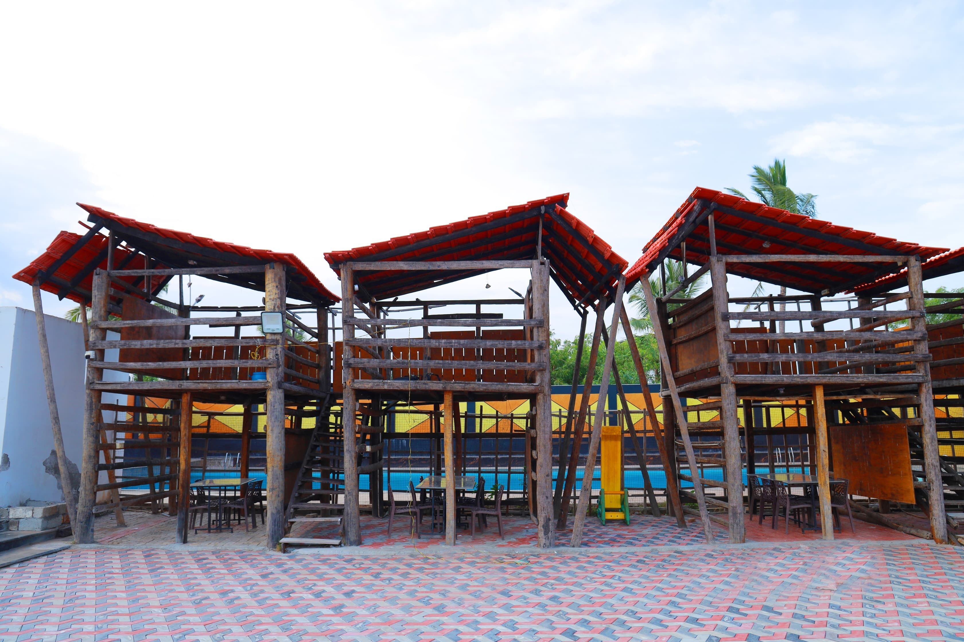 Zona de piscina amb estructures de fusta i un paviment de rajoles.