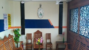 Une pièce meublée de meubles en bois, avec une horloge et un panneau décoratif au mur.