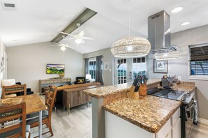 A modern kitchen with granite countertops, a built-in stove, and a ceiling fan. - Beachfront South Padre Island condo with bay views, sunsets, and SpaceX launches from your private deck. Sleeps 6 in 2 bedrooms (king and queen) plus convertible sofa. Chef's kitchen, WiFi, washer/dryer, fire pit, grill, free parking. Pet-friendly. (South Padre Island)
