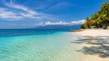 On the beach, white sand, sun loungers, beach umbrellas