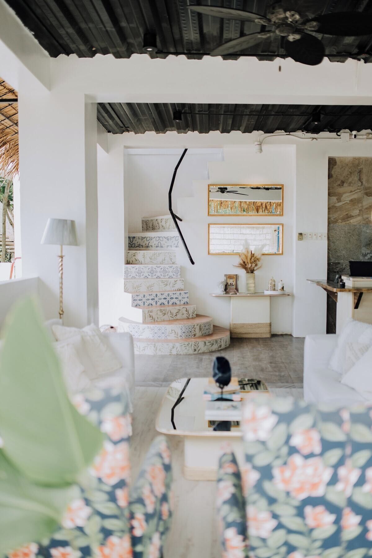 Un interior moderno con una escalera, un sofá y una mesa de centro.