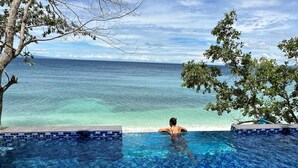Una persona in piscina con vista sull'oceano.