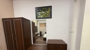 Una habitació amb un armari, una taula petita i un quadre al mur.