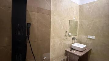 Une salle de bain moderne équipée d’une douche, de toilettes, d’un lavabo et d’un miroir.