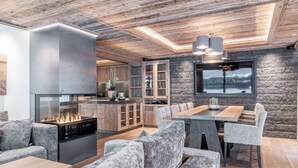 Un interior moderno con chimenea, zona de estar, cocina y pared de piedra.