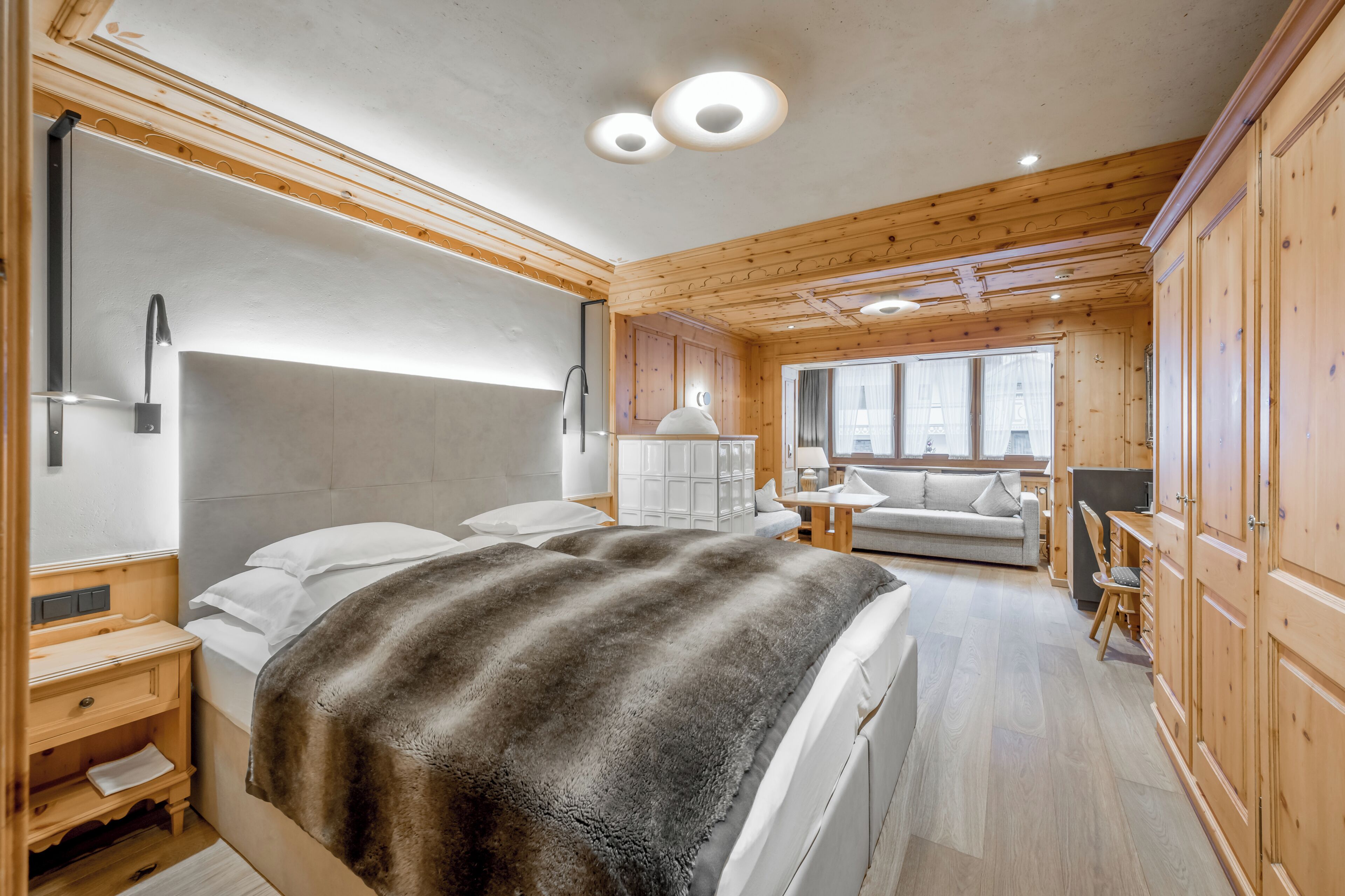 Une chambre moderne avec un grand lit, des murs en bois et une vue sur le salon.
