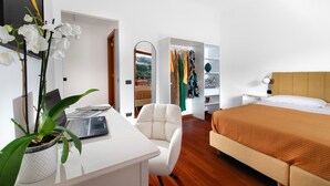 A bedroom with a bed, a desk with a laptop, a chair, a wardrobe, and a potted plant. - Estate4home - Casa Marelia (Sorrento)