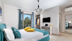 A bedroom with a bed, a desk, a TV, and a balcony. - Villa Elios in Massa Lubrense (Massa Lubrense)