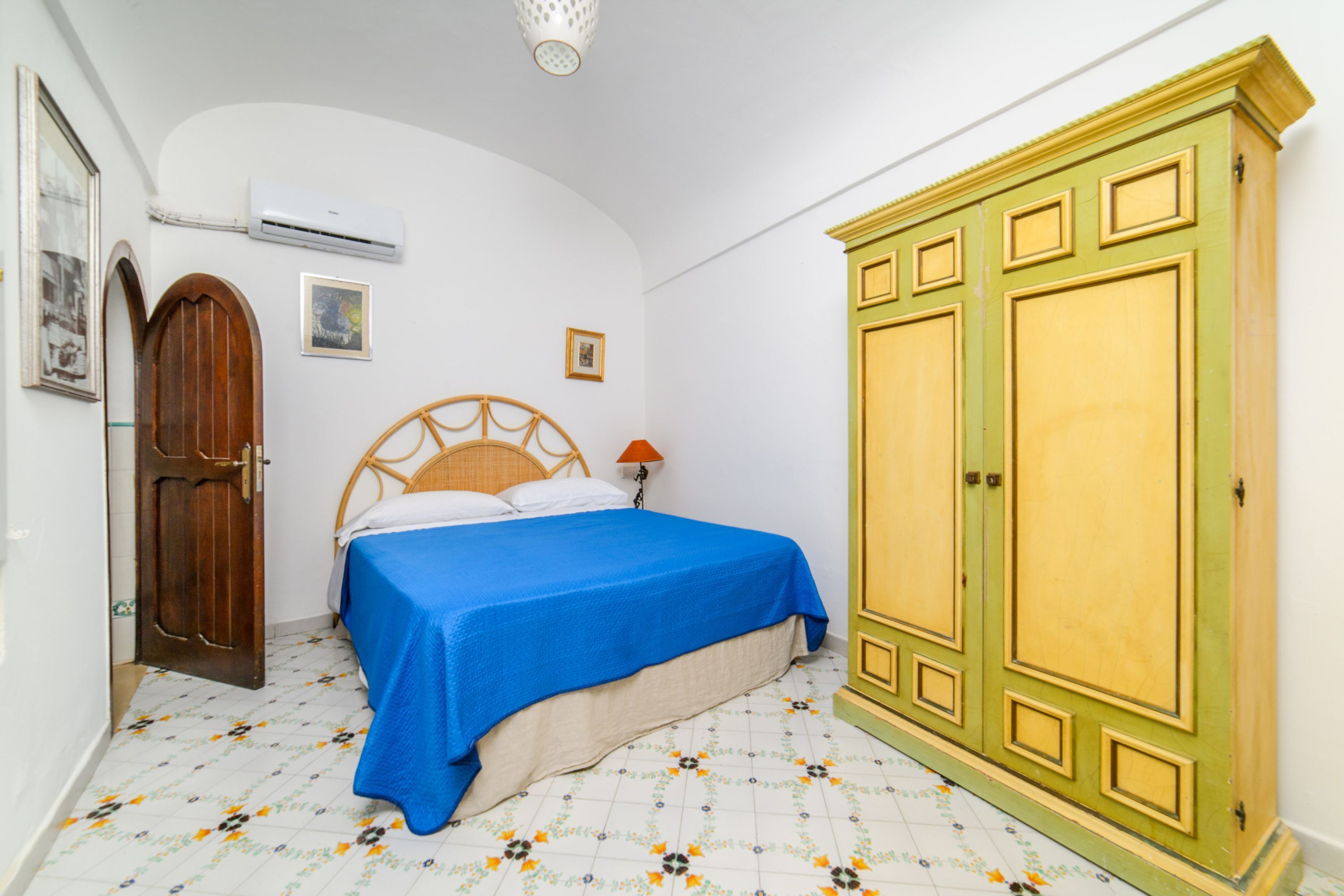 A bedroom with a bed, wardrobe, and a door.