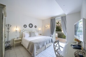 A bedroom with a bed, bedside table, lamp, and a view of a balcony. - Villa Isea Positano in Positano (Positano)