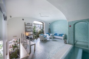 A spacious living area with a balcony, a sofa set, and a view of the cityscape. - Villa Isea Positano in Positano (Positano)