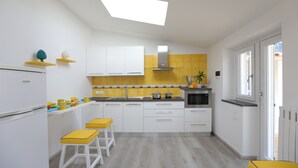 A modern kitchen with white cabinets, a yellow backsplash, and a skylight. - Relais Villa Chiara in Sorrento (Sorrento)