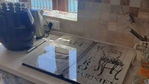 Una cucina con vista sul mare, un bollitore, una macchina da caffè e un tavolino decorato a tema Parigi.