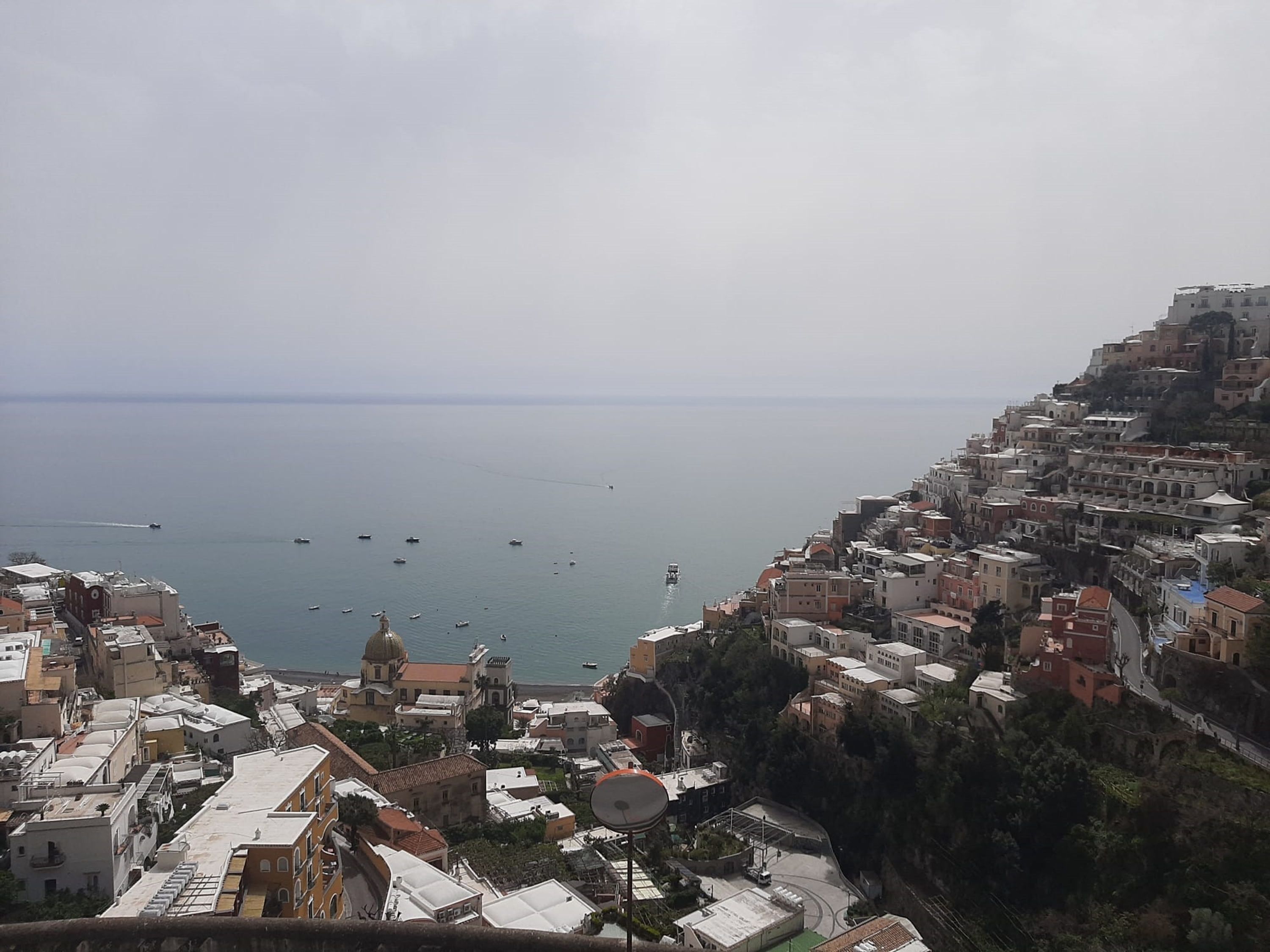 A coastal town with buildings on a hillside overlooking the sea.
