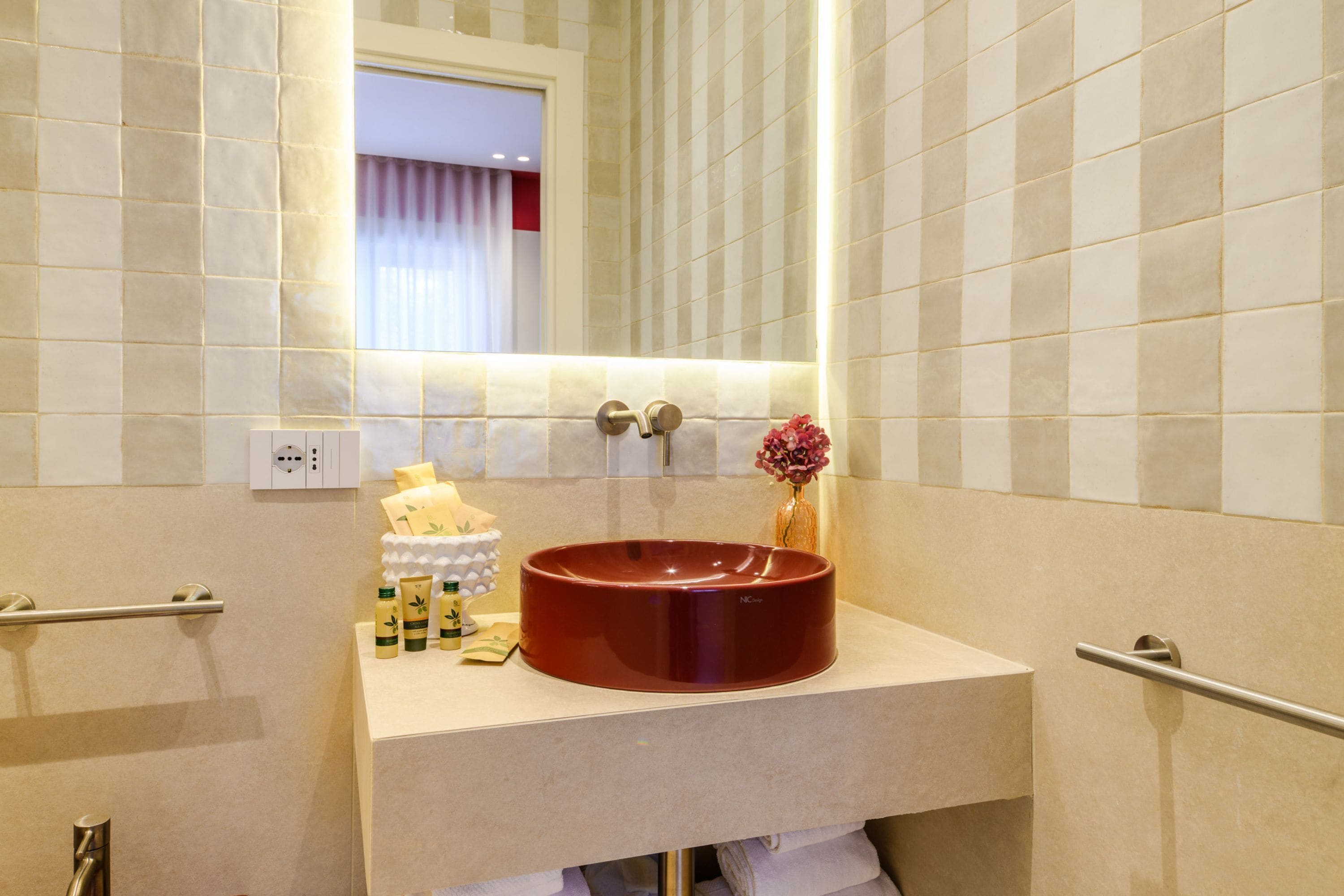 Un baño con un lavabo redondo, un espejo y un perchero para toallas.