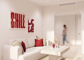 Un salon moderne avec un canapé blanc, des coussins rouges et beige, une table basse agrémentée d’objets décoratifs et des œuvres d’art abstraites accrochées au mur.