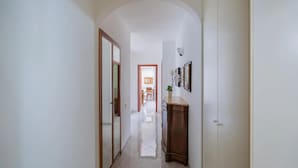 A hallway with a tiled floor, a wooden cabinet, and a door. - Casa Cinzia - Apartment (Vico Equense)