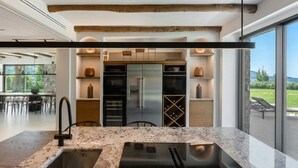 Una cucina moderna con un'isola grande, elettrodomestici integrati e vista sull'esterno.