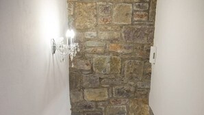 A narrow staircase with a stone wall and a wall-mounted light fixture. - Asfendamos Villas - With 2 Private Pools (Mylopotamos)