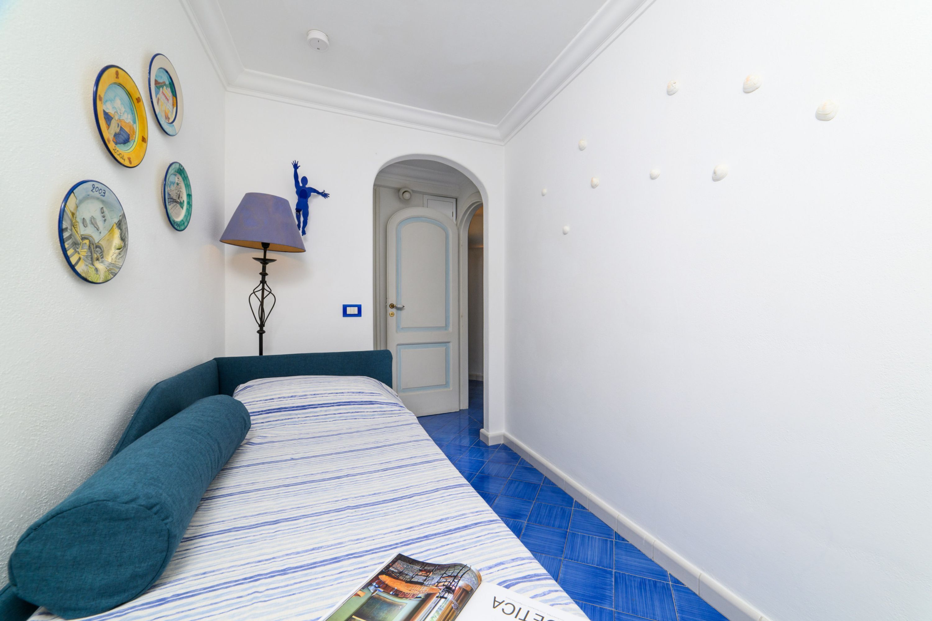 Une chambre à coucher avec un lit, une lampe et des éléments de décoration murale.