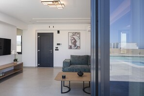 Ein modernes Wohnzimmer mit einer Couch, einem Couchtisch, einem Fernseher und einem Gemälde an der Wand.
