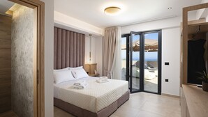 A modern hotel room with a bed, a nightstand, a lamp, a sliding glass door to a balcony, and a wooden wardrobe. - Elysioum Pearl Villas - With 2 Private Pools (Mylopotamos)