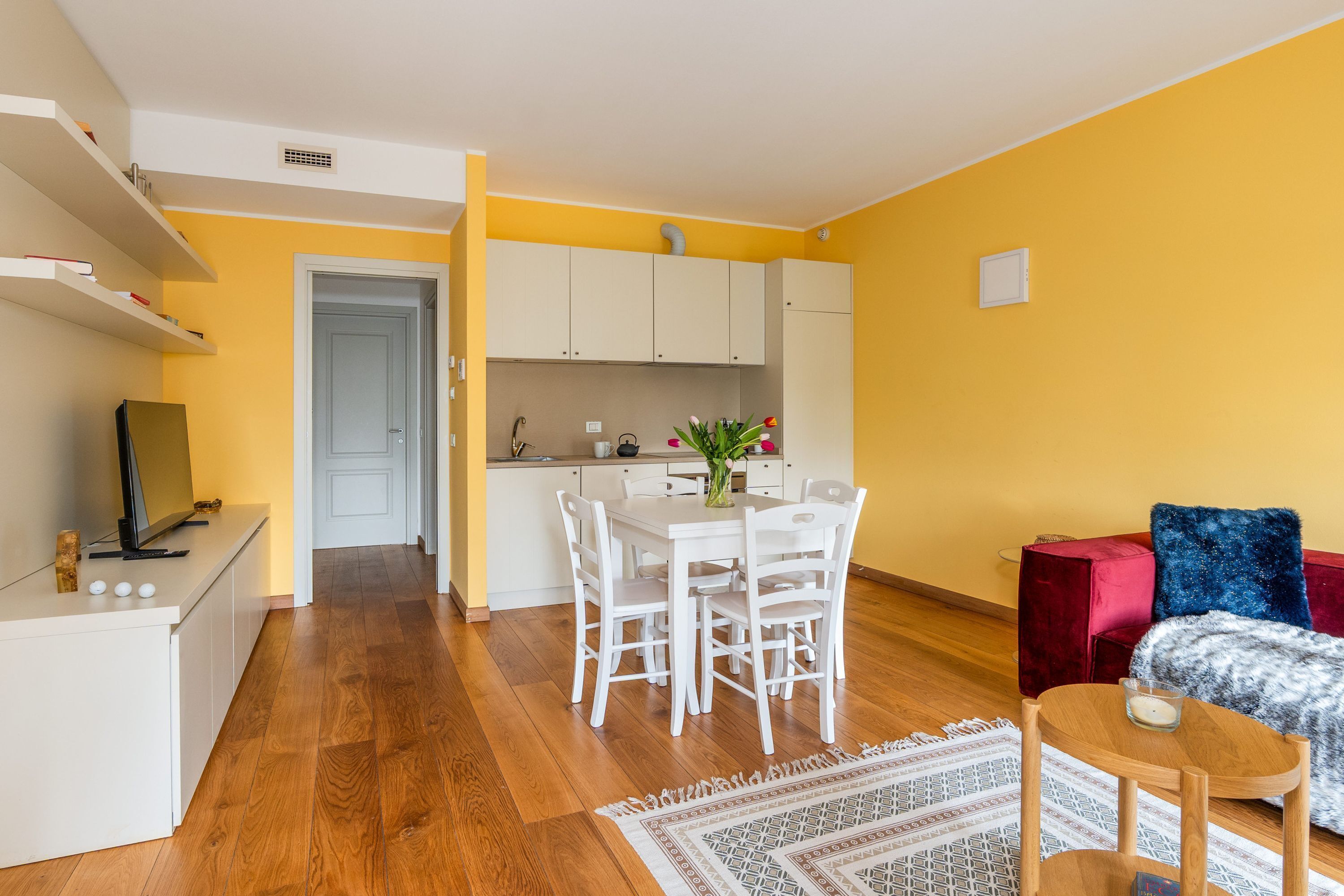 Un espace de vie compact comprenant un coin repas, une cuisine et un coin salon.
