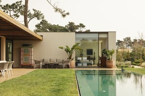 A modern house with a swimming pool, outdoor seating, and a well-maintained lawn. - Moon Forest Retreat by Cadenzalux (Sintra)