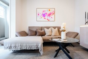 Ein stilvolles Wohnzimmer mit einer Couch, einem Couchtisch und einer dekorativen Vase.