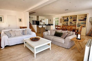Ein Wohnzimmer mit zwei Sofas, einem Couchtisch und einem Bücherregal.