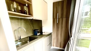 A kitchen with a sink, stove, and wooden cabinets. - Tiny House near Forstsee – Nature, Tranquility & Lakes (Greilitz)