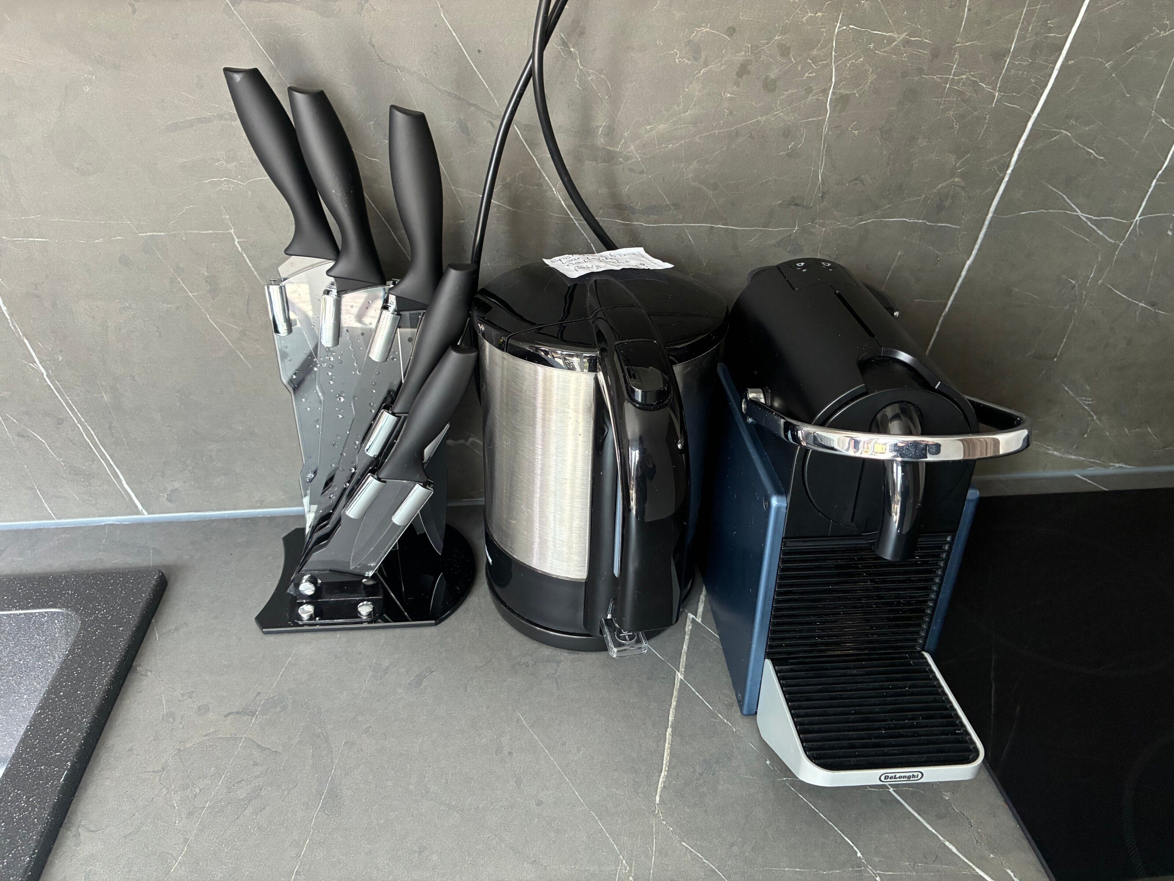 Een keuken met een koffiezetapparaat, waterkoker en broodrooster.