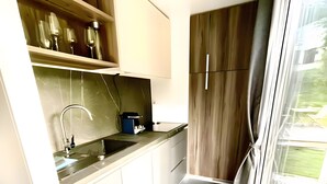 Une cuisine compacte dotée d’une cuisinière intégrée, d’un évier et d’armoires en bois.