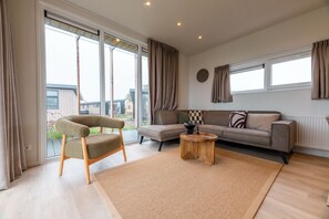 Una sala de estar moderna con un sofá, una silla y una mesita de centro.