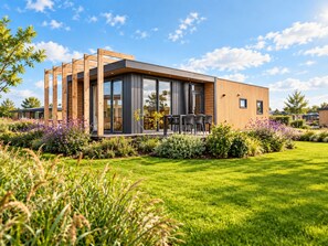 A modern house with a deck, surrounded by a well-maintained garden. - Enjoy stylish comfort in the Duinrand Lodge for 6 persons. This cozy and spacious holiday home offers everything you need for a truly relaxing holiday. (De Haan)