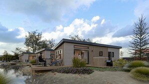 Een modern gebouw met een zwembad, terras en een jacuzzi.