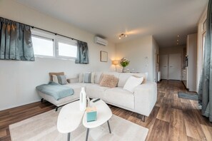 Een moderne woonkamer met een bank, een salontafel en een lamp.