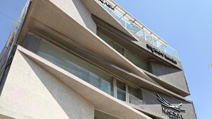 Un hotel moderno con un cartel llamativo que dice 'NestSoft Hotel' y un área con balcón.
