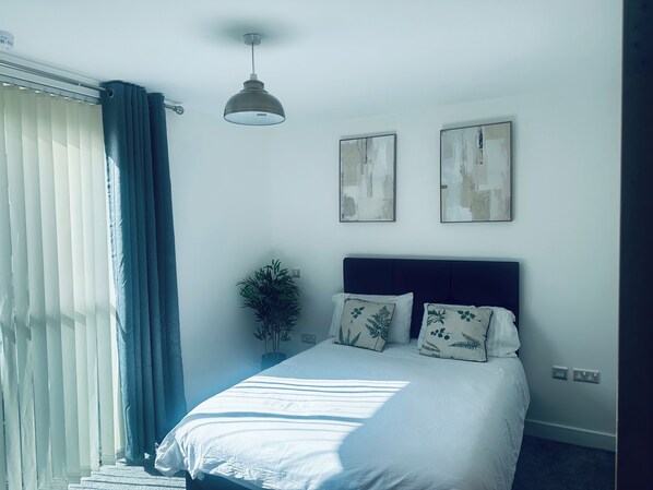 A bedroom with a bed, a ceiling fan, a window with curtains, and two wall-mounted artworks. - Modern2 Bedroom Apartment/private Parking /sleep 5/balcony View in Birmingham City Centre (Birmingham)