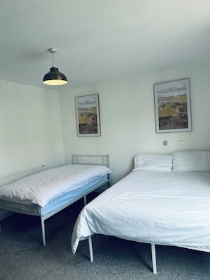 A room with two beds, a ceiling light, and two framed pictures on the wall. - Modern2 Bedroom Apartment/private Parking /sleep 5/balcony View in Birmingham City Centre (Birmingham)