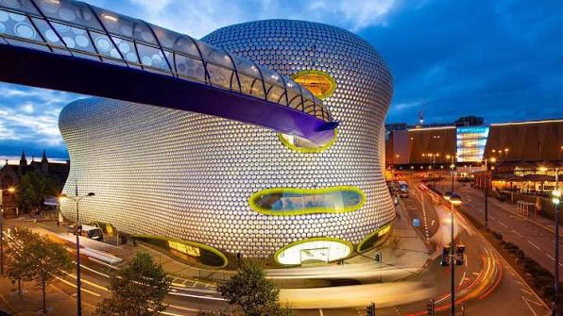 A modern architectural building with a spherical design, featuring a prominent circular window and a curved entrance.