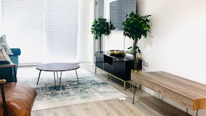 Een moderne woonkamer met een bank, salontafel en een lange bank.